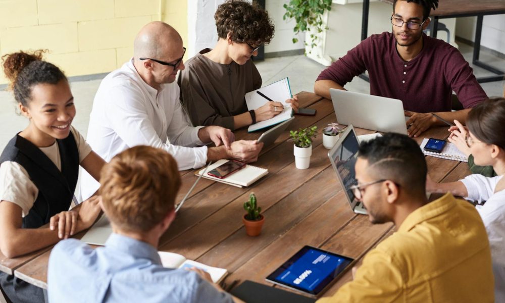 A group of professionals having a meeting in a modern office environment, fostering teamwork and brainstorming.