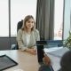 Young woman sitting confidently in a modern office for a job interview.