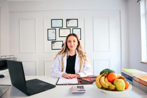 a woman sitting at a desk in front of a laptop