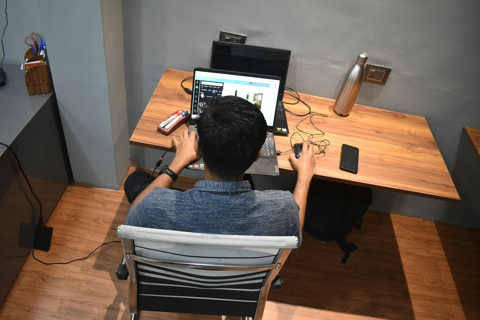 A person sitting at a desk with a laptop
