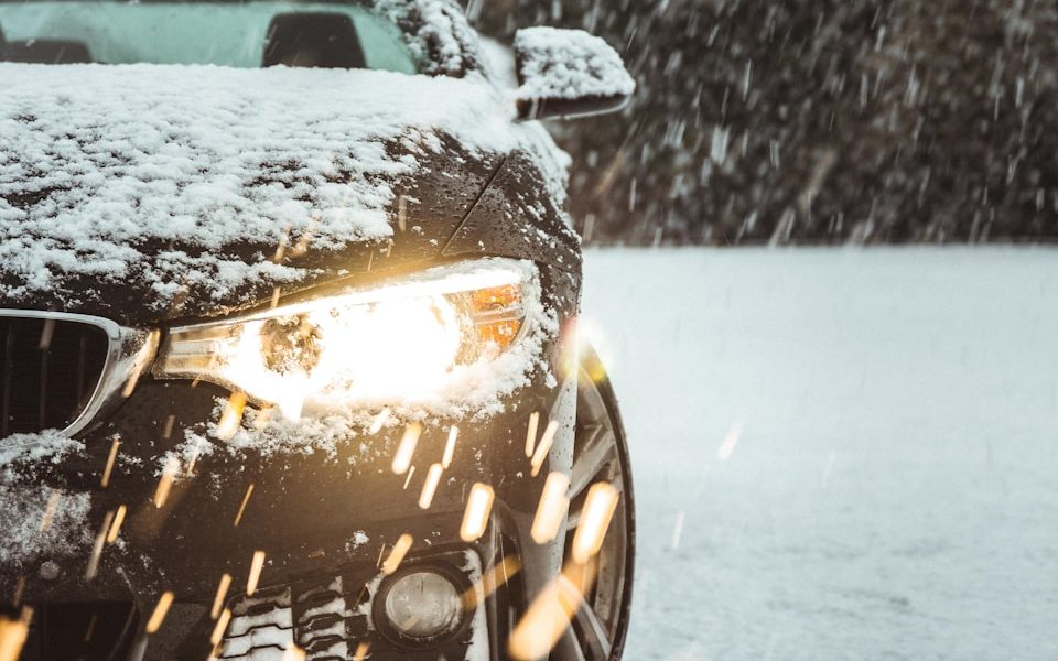 black car on snow covered road during daytime